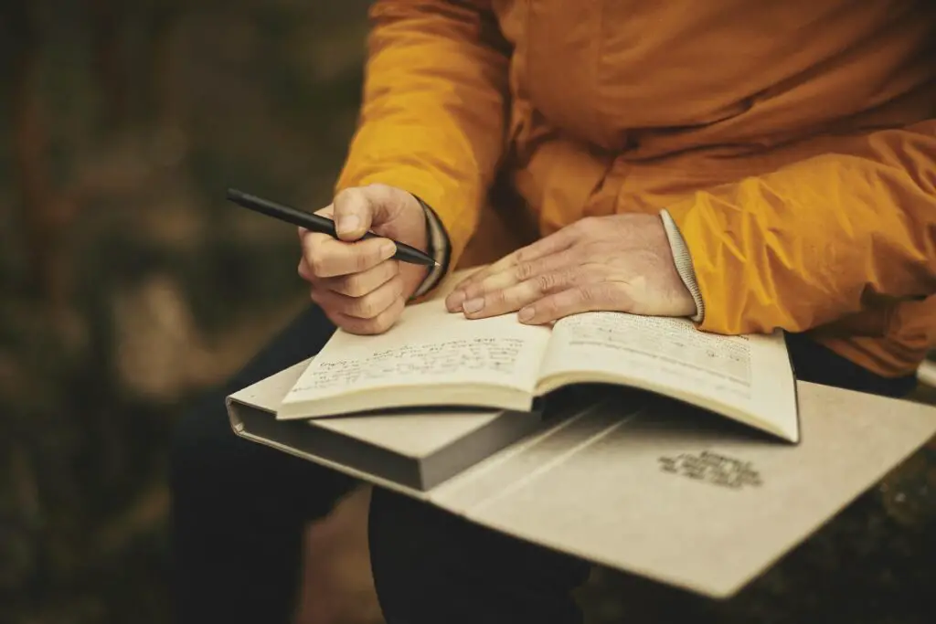 This image shows a man journaling. It's used for the article, "my girlfriend is talking to another guy behind my back" 