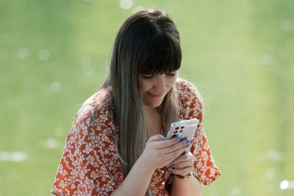 This image shows a woman on her phone. It's used for the article "why is my girlfriend so annoying" 