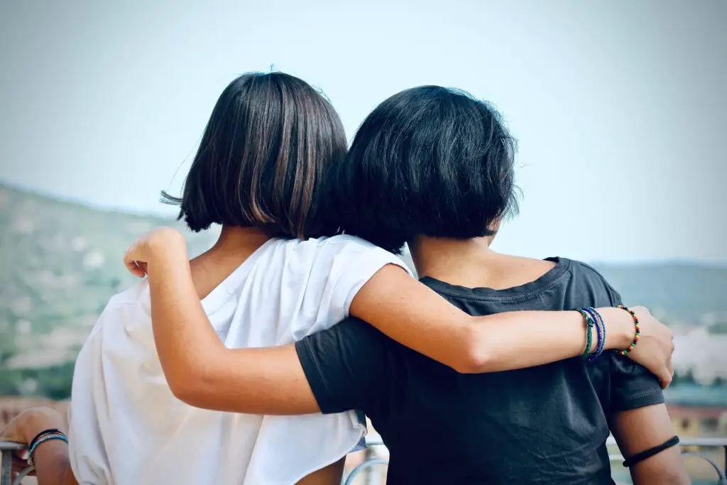 This image shows a woman embracing her friend through a difficult time. It's used for the article, "girlfriend chooses friends over me" 