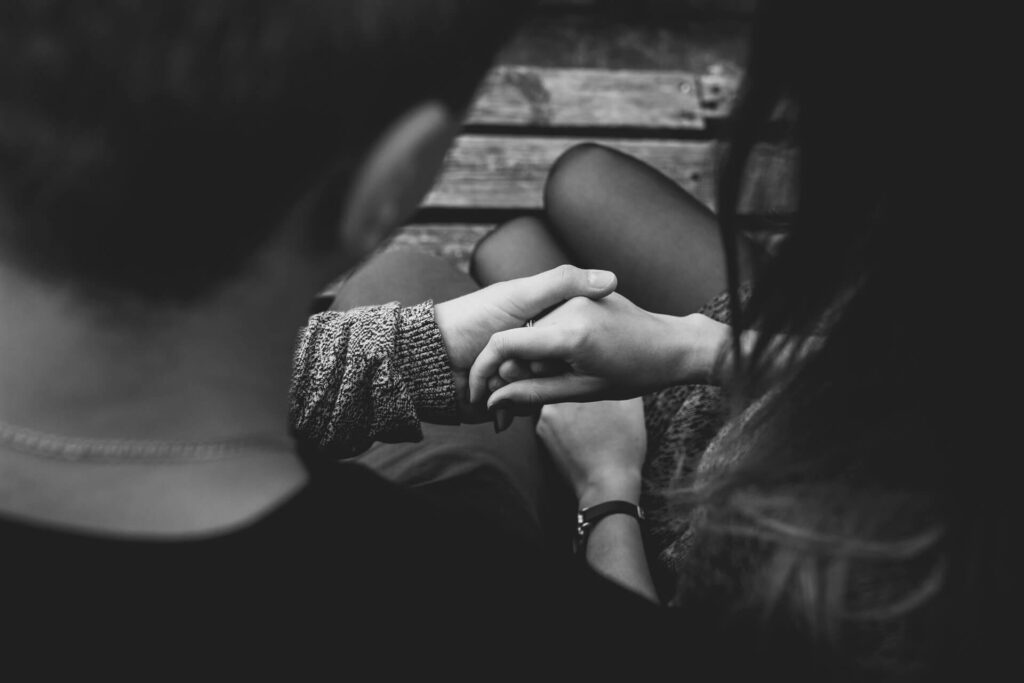 This image shows a boyfriend consoling her girlfriend by holding her hand. It's used for the article, 12 Reasons Why My Girlfriend Keeps Talking About Her Ex