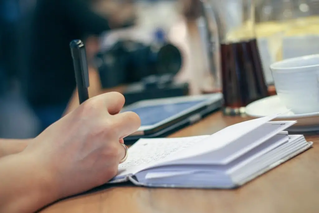 This image shows a woman writing her thoughts. It's used for the article, My boyfriend hasn't said I love you in 9 months 