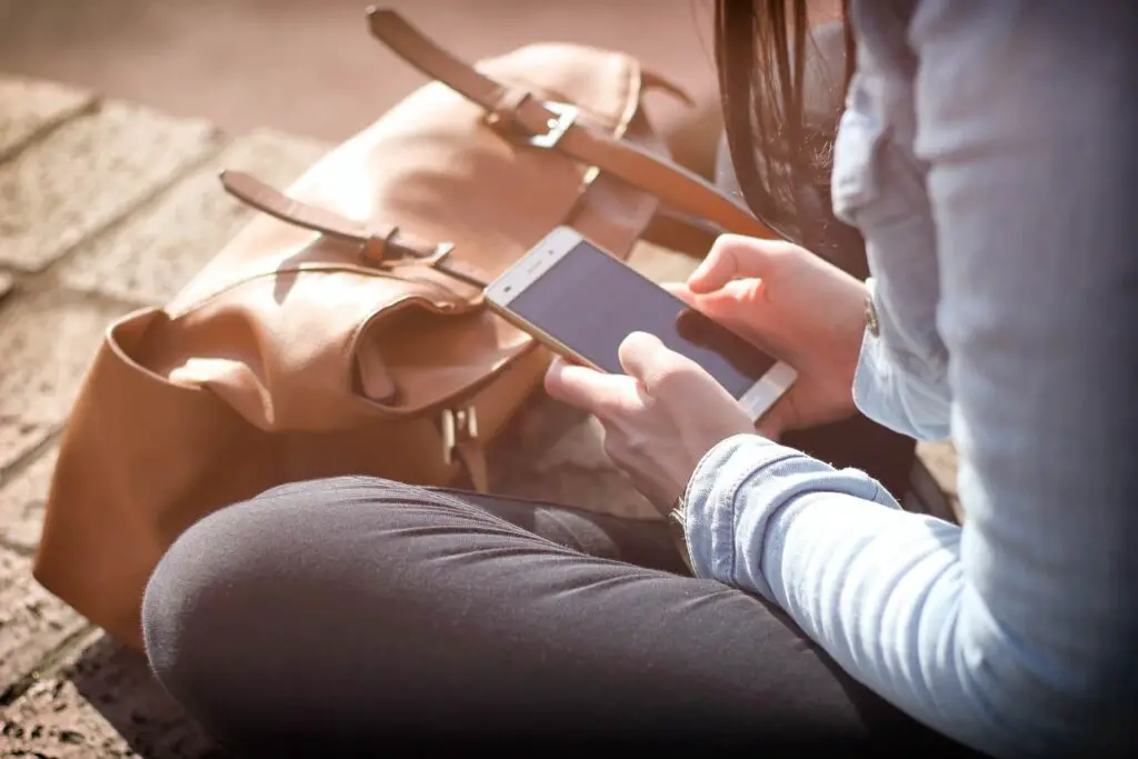 This is an image of a woman reaching out to her boyfriend via text. It's used for the article, My boyfriend hasn't texted me all day