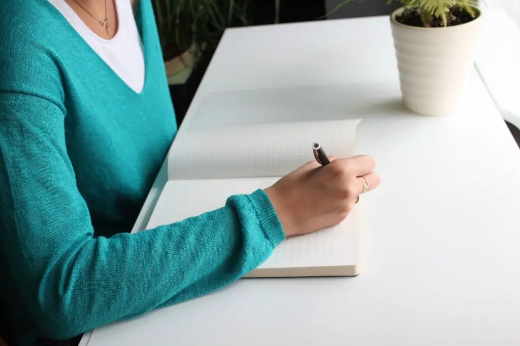 This image shows a woman journaling. It's used for the article, "My boyfriend makes me feel bad about myself" 