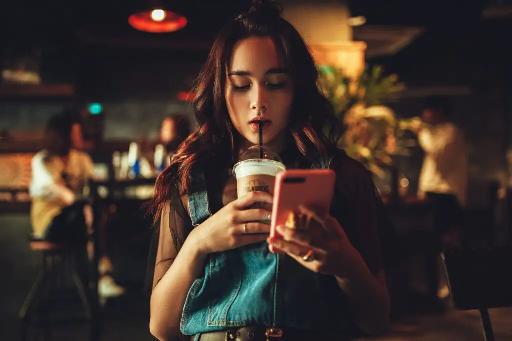 This image shows a woman preoccupied on her phone.  It's used for the article "My boyfriend thinks I don't love him" 