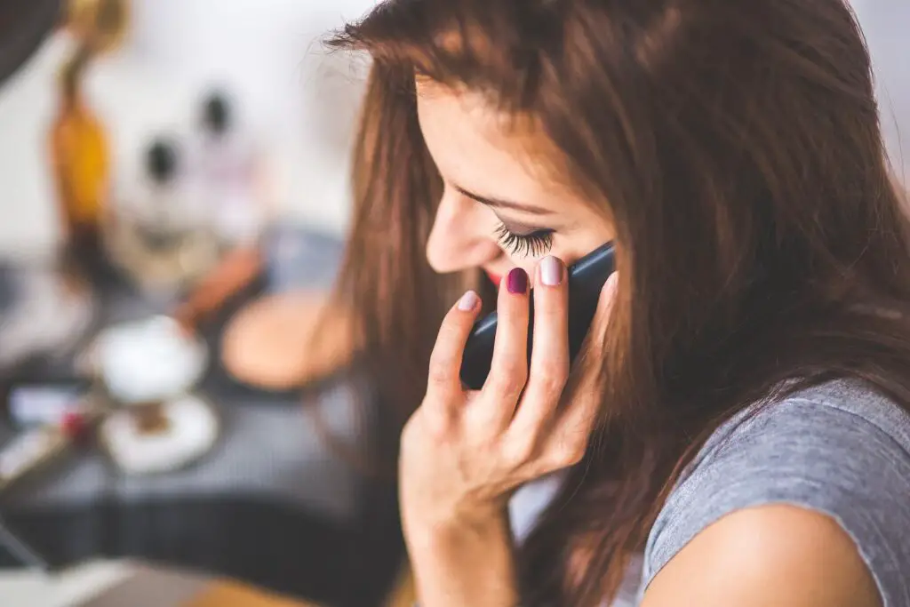 This image shows a woman who's bored on the phone. It's used for the article "My girlfriend never checks up on me" 