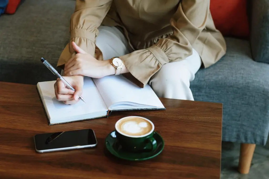 This image shows a woman journaling. It's used for the article "3 harsh facts long-distance relationships" 