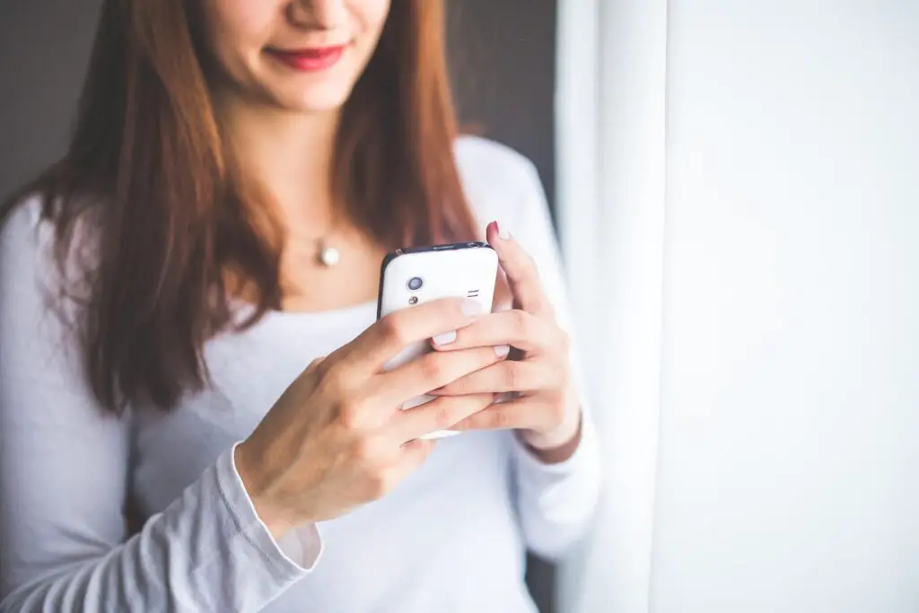 This image shows a woman texting. It's used for the article, "good morning message for long-distance couple" 