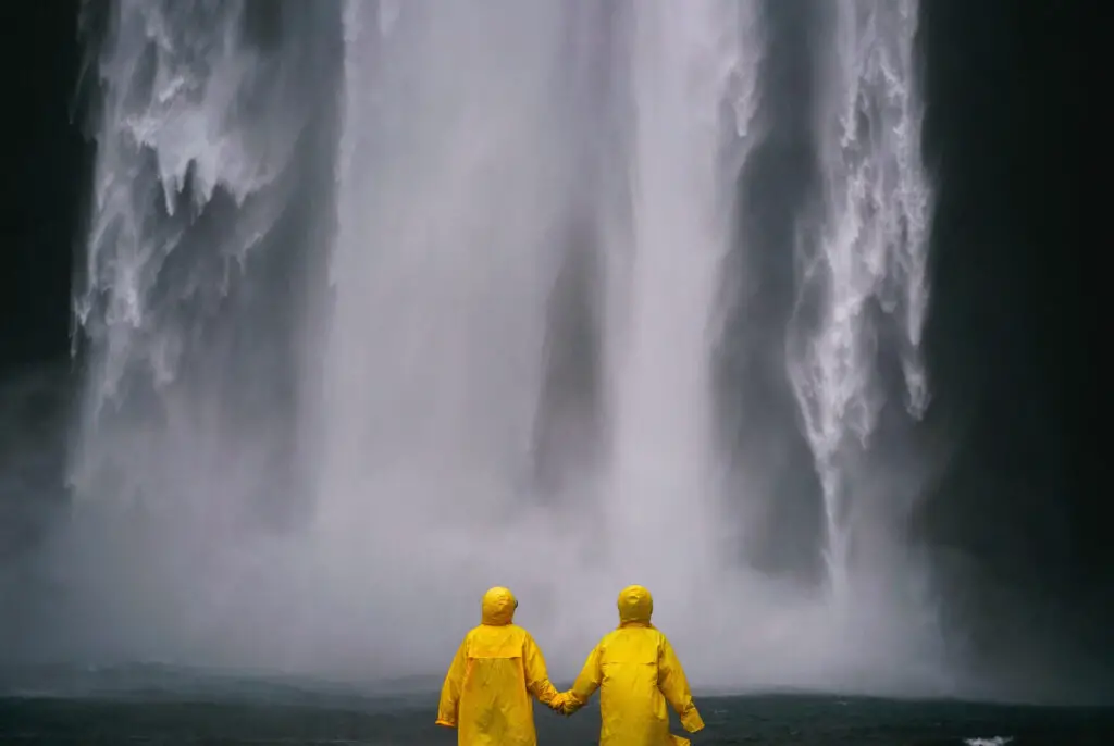 This image shows a couple standing in front of a waterfall. It's used for the article "motivational quotes for long-distance relationships" 