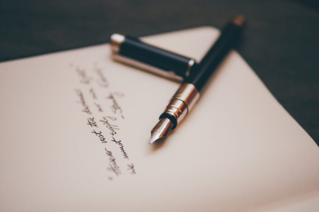 This image shows a piece of writing and pen. It's used for the article "fun things to do long-distance relationship"