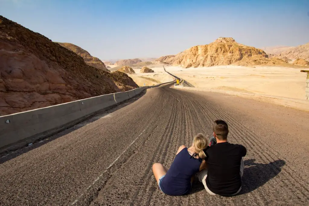 This image shows a couple staring at a long road. It's used in the article "how to save long-distance relationship"