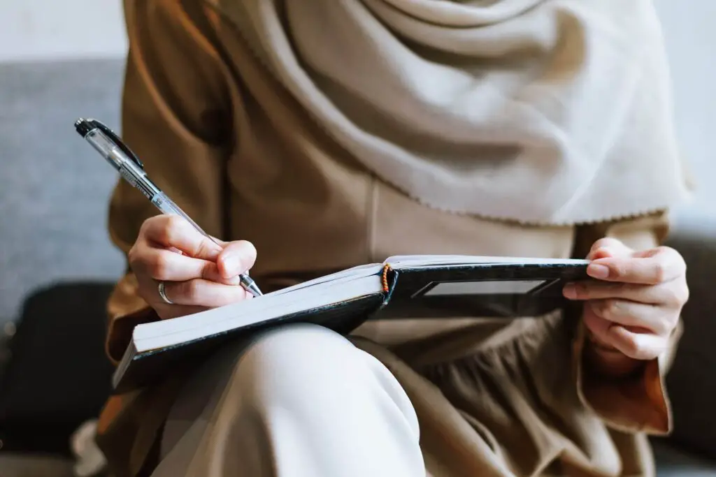 This image shows a woman writing on her journal. It's used for the article "jealousy in a long-distance relationship"