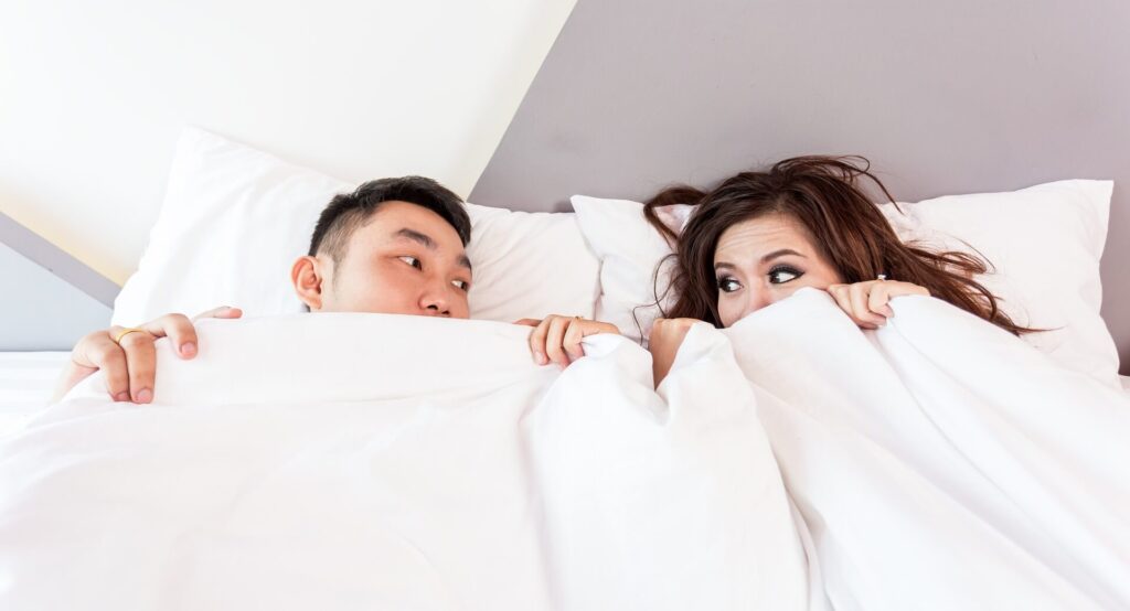 This image shows a couple in bed. It's used in the article "long distance relationship conversation topics" 