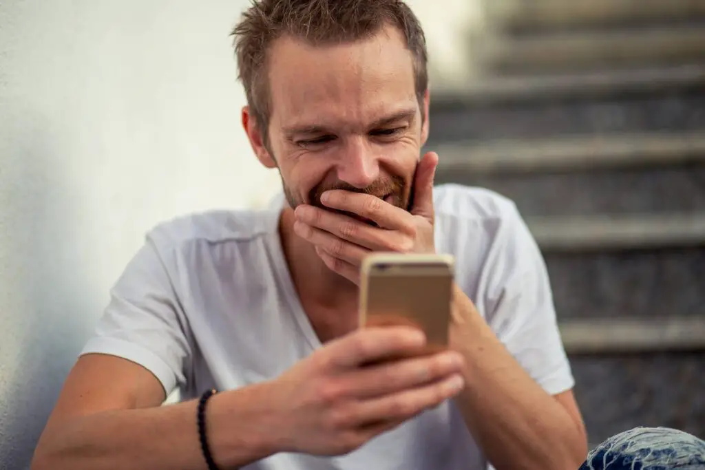 This image shows a man using her phone. It's used for the article "long distance relationships apps" 